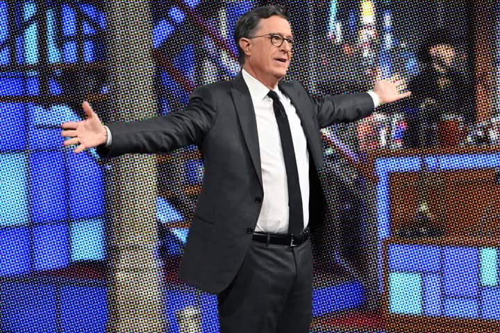 Stephen Colbert on stage, arms wide open